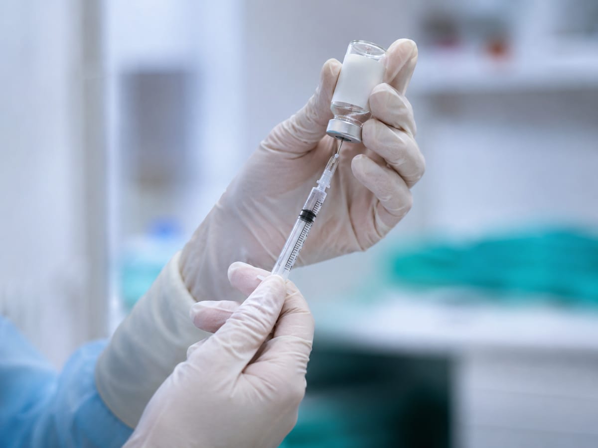 Preparação de seringa com dose da vacina da gripe trivalente 2026